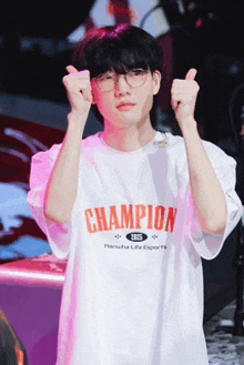 a young man wearing a white champion shirt giving a thumbs up