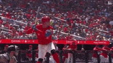 a baseball player swings his bat in front of a banner that says rogers