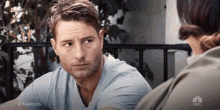 a man and a woman are sitting at a table and talking to each other .