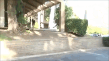 a man is walking down a sidewalk in front of a building that has the number 72 on it