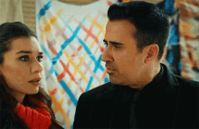 a man and woman are looking at each other in front of a painting