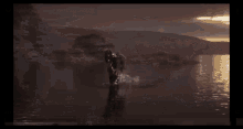 a man is doing a trick on a motorcycle in the water with a skull and crossbones logo in the corner