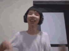 a young man wearing headphones is dancing and smiling .