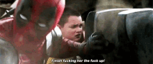 a man in a deadpool costume is holding a child and says `` finish fucking her the fuck up '' .