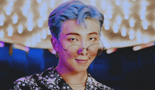 a man with blue hair wearing glasses and earrings