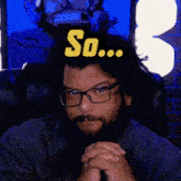 a man with glasses and a beard has a sticker on his head that says so