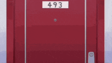 a person is standing in front of a red door with a sign that says 493 on it .