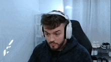 a man with a beard wearing headphones looks at the camera