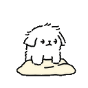 a small white dog is standing on top of a pile of sand .
