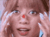 a close up of a woman 's face with a red patch on her nose