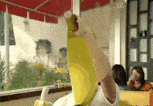 a person wearing a banana costume is holding a banana in their hand