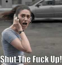 a woman talking on a cell phone with the words shut the fuck up written below her