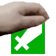 a hand is holding a green box with a white x on it .