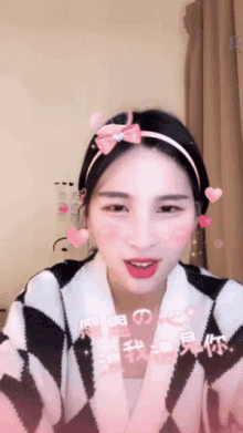 a girl wearing a headband with hearts and a bow on it
