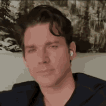 a man wearing ear buds is sitting on a couch .