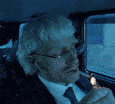 a man in a suit and tie is lighting a cigarette with a lighter