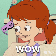 a cartoon girl with red hair is sitting on a bed and the word wow is above her head