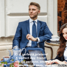 a man in a suit and tie sits at a table next to a woman