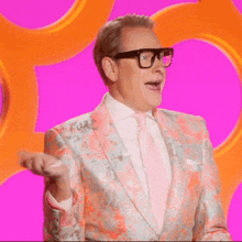 a man in a colorful suit and tie is making a funny face .