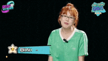 a woman wearing glasses and a green adidas shirt says " cawite "