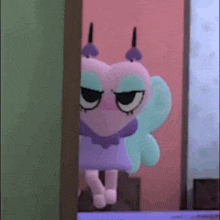 a cartoon character with a heart shaped head and wings is peeking out from behind a door .