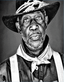 a black and white photo of an older man wearing a cowboy hat