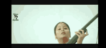 a woman in a white dress is holding a sword .