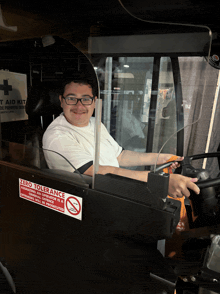 a man is driving a bus with a zero tolerance sign on the side