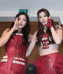 two women standing next to each other with one wearing a glove