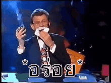 a man in a suit is smoking a cigarette while holding a napkin in his mouth
