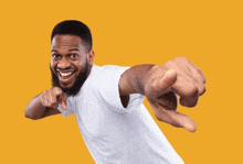 a man in a white shirt is pointing to the camera