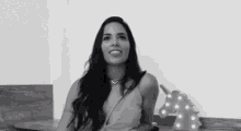 a black and white photo of a woman sitting at a table with a unicorn in the background .