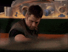 a man sitting in front of a hamster cage looking down