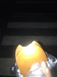 a sandwich with a bite taken out of it is sitting on the ground