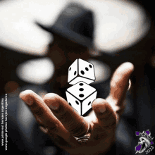 a man in a hat holds two dice in his hand