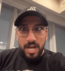 a man wearing glasses and a hat that says al on it