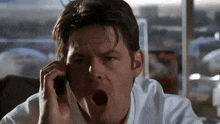 a man talking on a cell phone with his mouth wide open