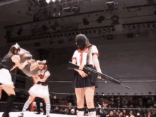 a woman is holding a gun in a wrestling ring .