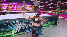 a woman in a wrestling ring with a sign that says wrestlemania on it