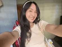 a woman takes a selfie with a headband that says pearls on it