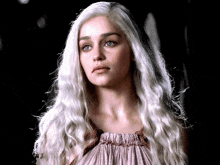 a woman with long white hair and blue eyes is wearing a pink dress