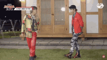 two men are standing next to each other in front of a building with a sign that says mnet