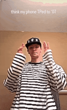 a man wearing a striped shirt and a hat with the words think my phone tped to 07