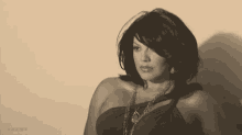 a woman is wearing a black dress and a necklace .