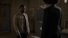 a man in a white jacket stands next to a woman in a black jacket