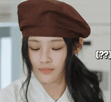 a close up of a woman wearing a brown hat with the word ( ?? ) in the corner