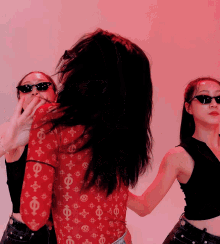 a woman wearing sunglasses and a red shirt with greek symbols