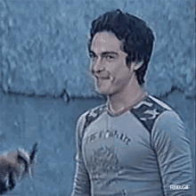 a man wearing a shirt that says ' ts couture ' on it smiles while being interviewed