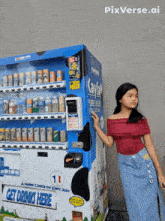 a girl standing in front of a kayla vending machine