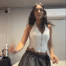 a woman is dancing in front of an air conditioner that says bosch on it